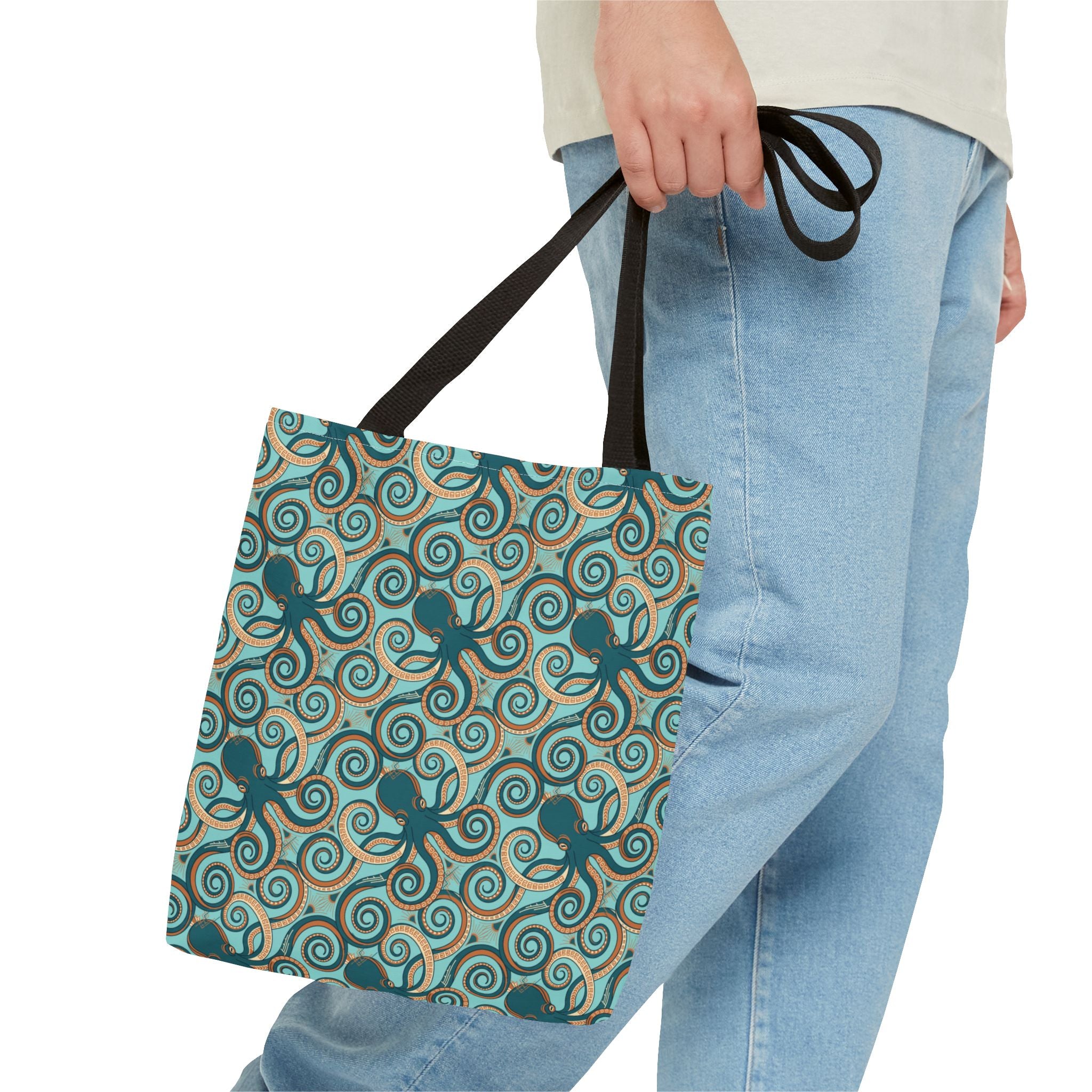 Octopus swirl tote bag with teal all-over print, held by person, black handles