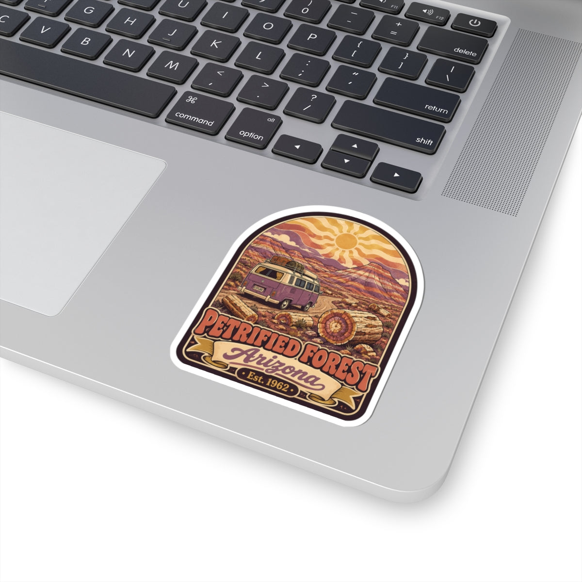 Kiss-cut desert camper van sticker on laptop, 'Petrified Forest Arizona Est. 1962' text.