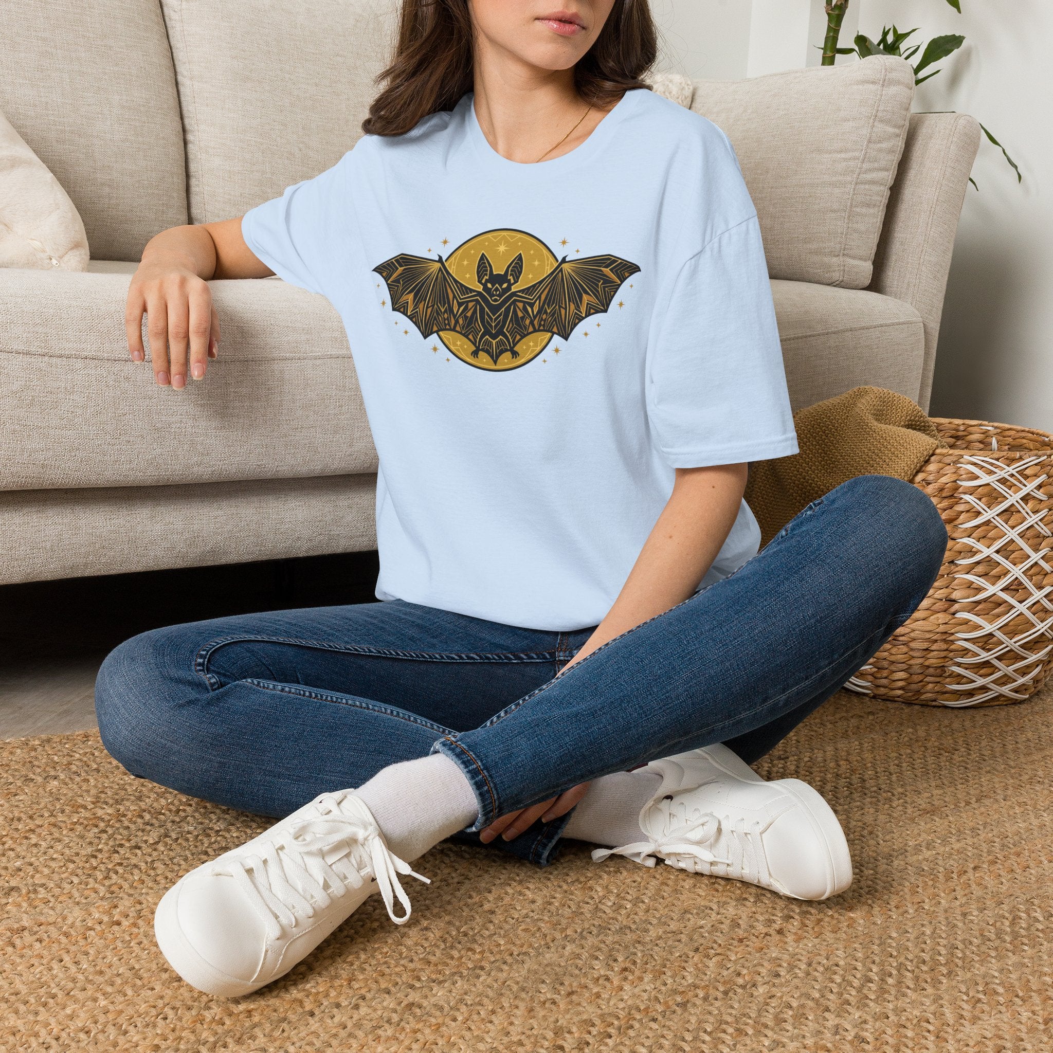 Light blue T-shirt worn with gold bat and moon graphic on the chest