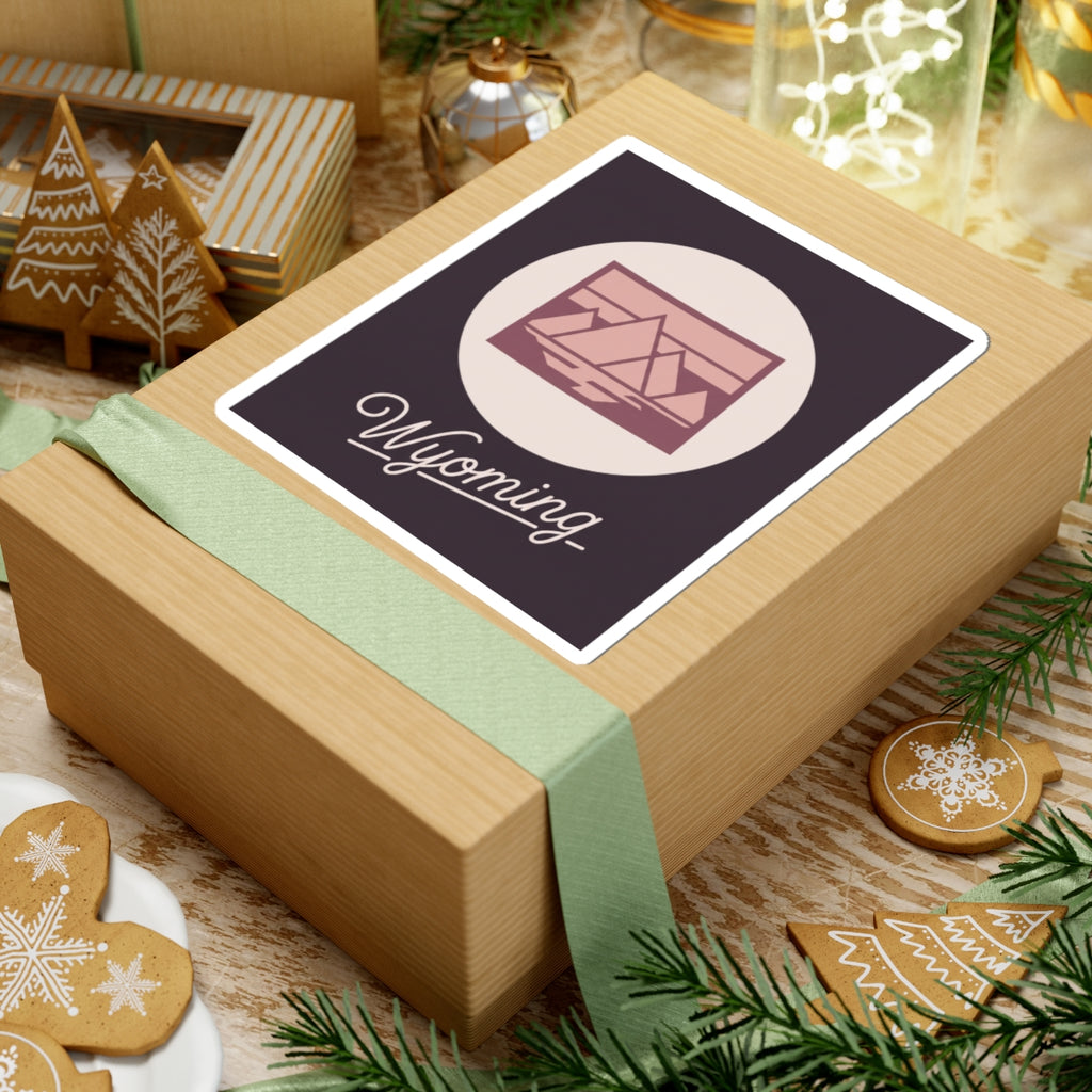 Wyoming sticker on wrapped box featuring pink landscape icon and cursive “Wyoming”