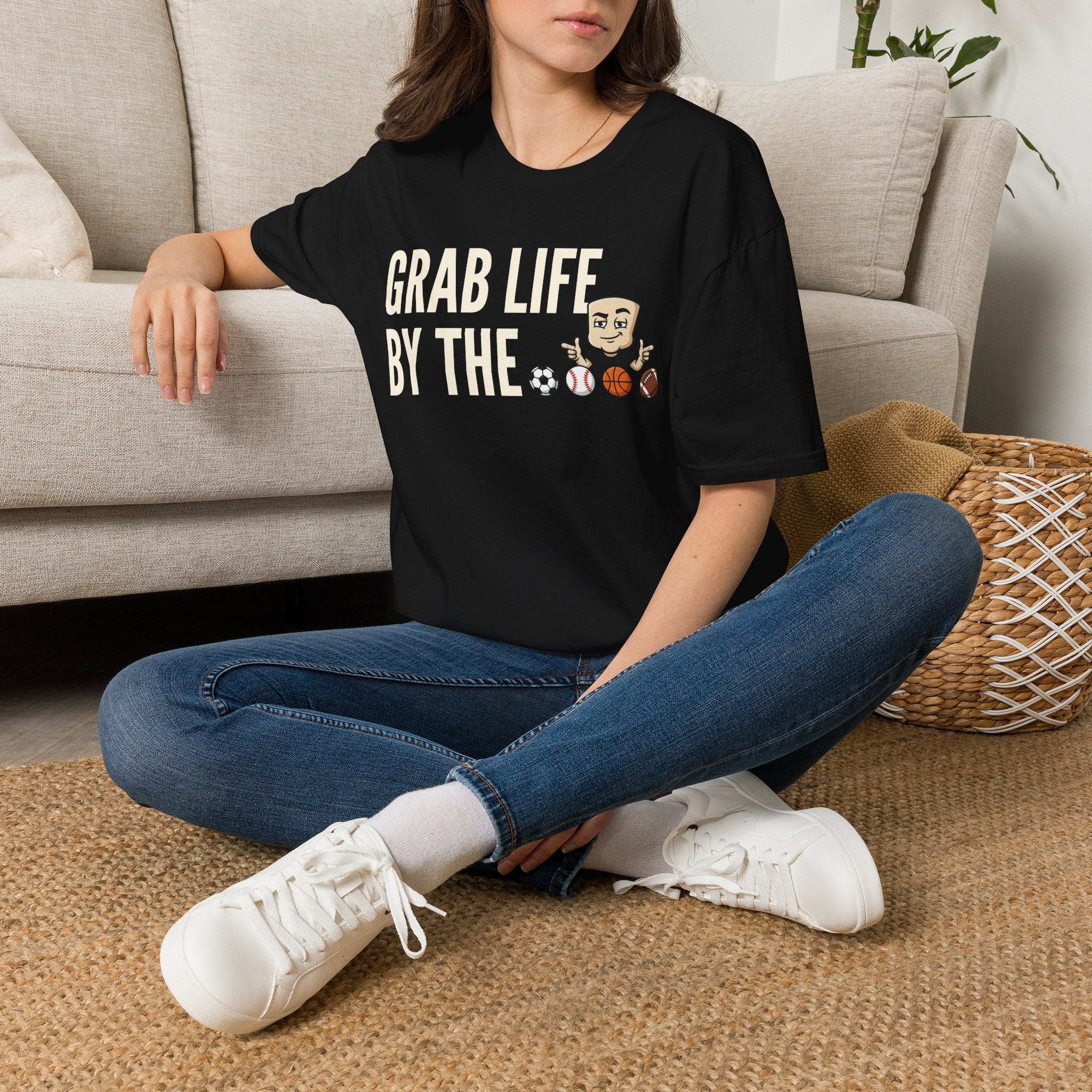 Black graphic T-shirt worn with jeans; motivational text and sports ball characters