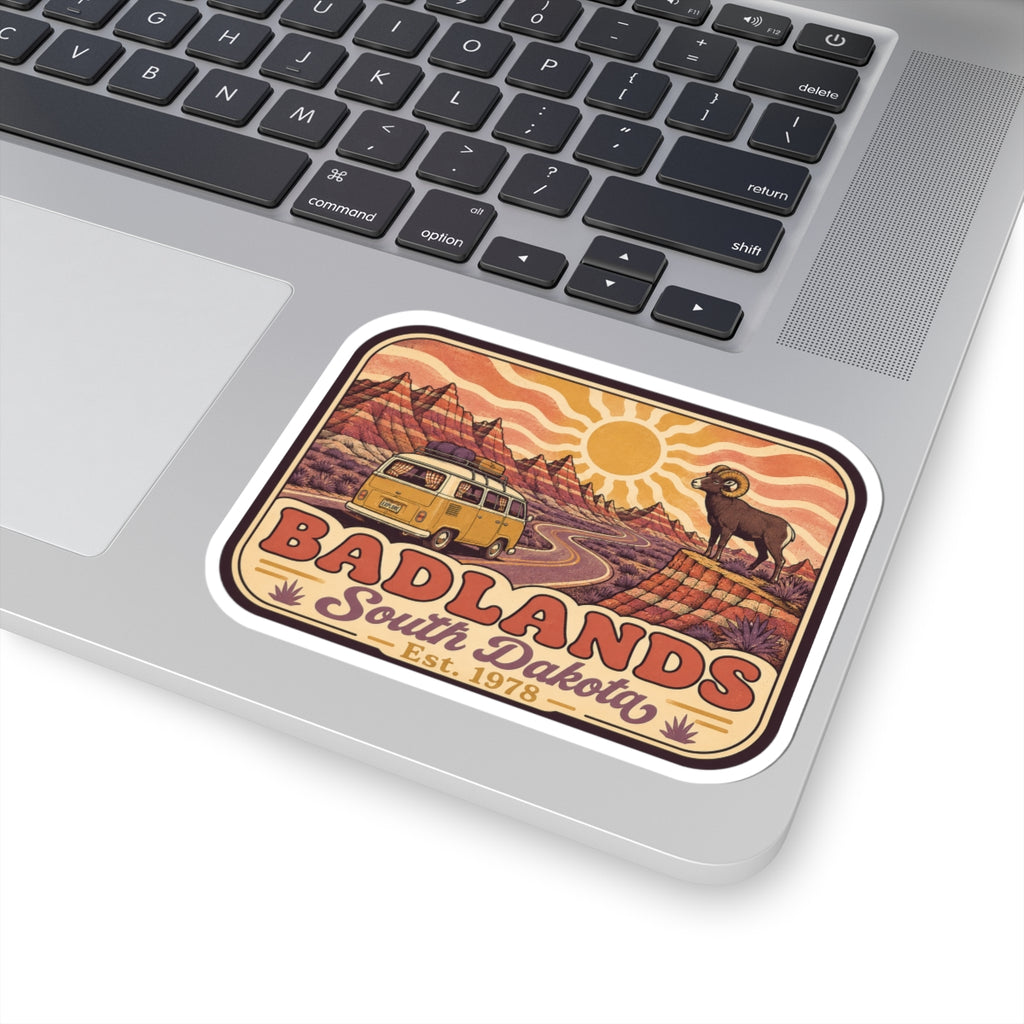 Kiss-cut sticker on laptop: desert cliffs and road with camper van, bighorn sheep, Badlands
