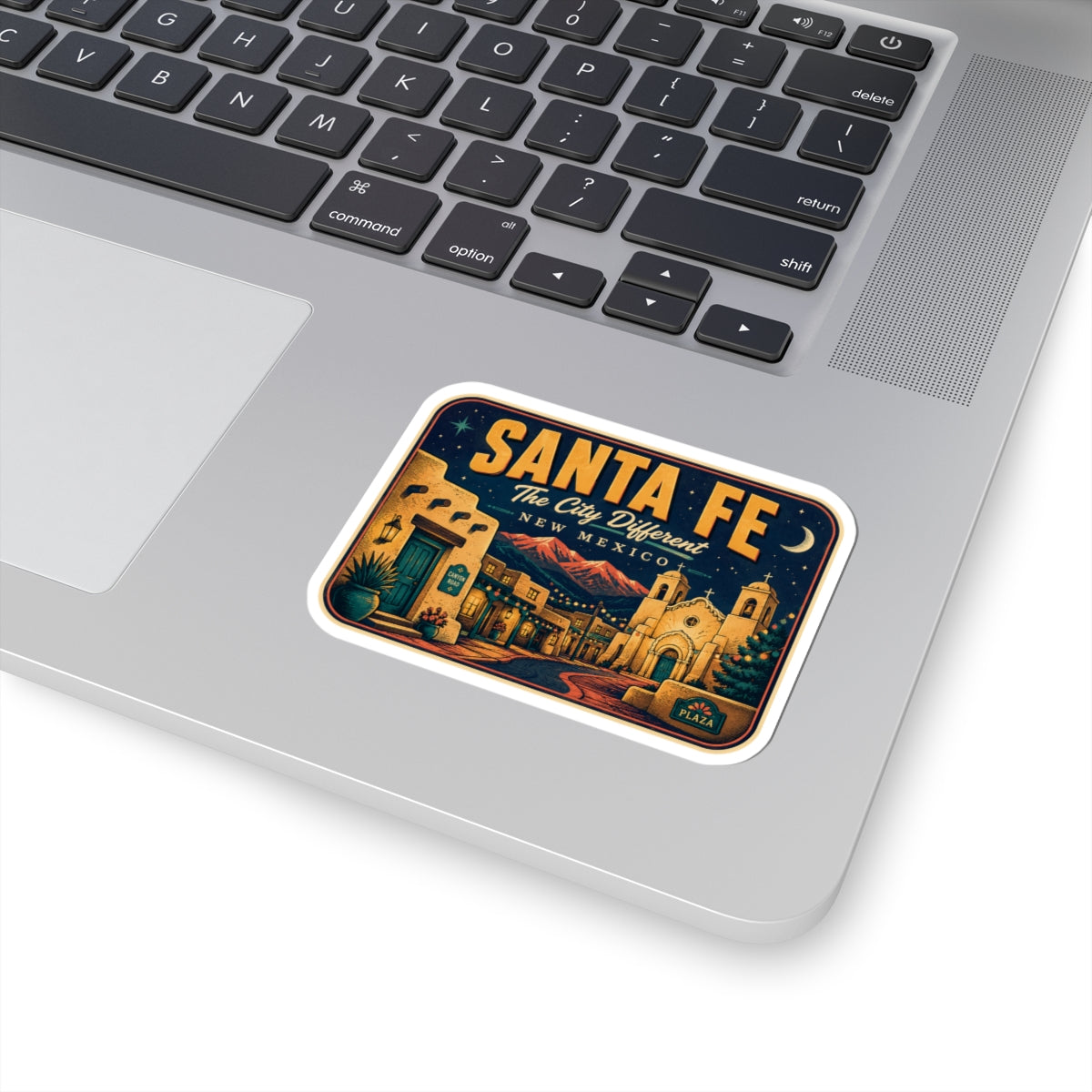 Santa Fe luggage tag sticker on a laptop, rectangular travel decal with desert town artwork.