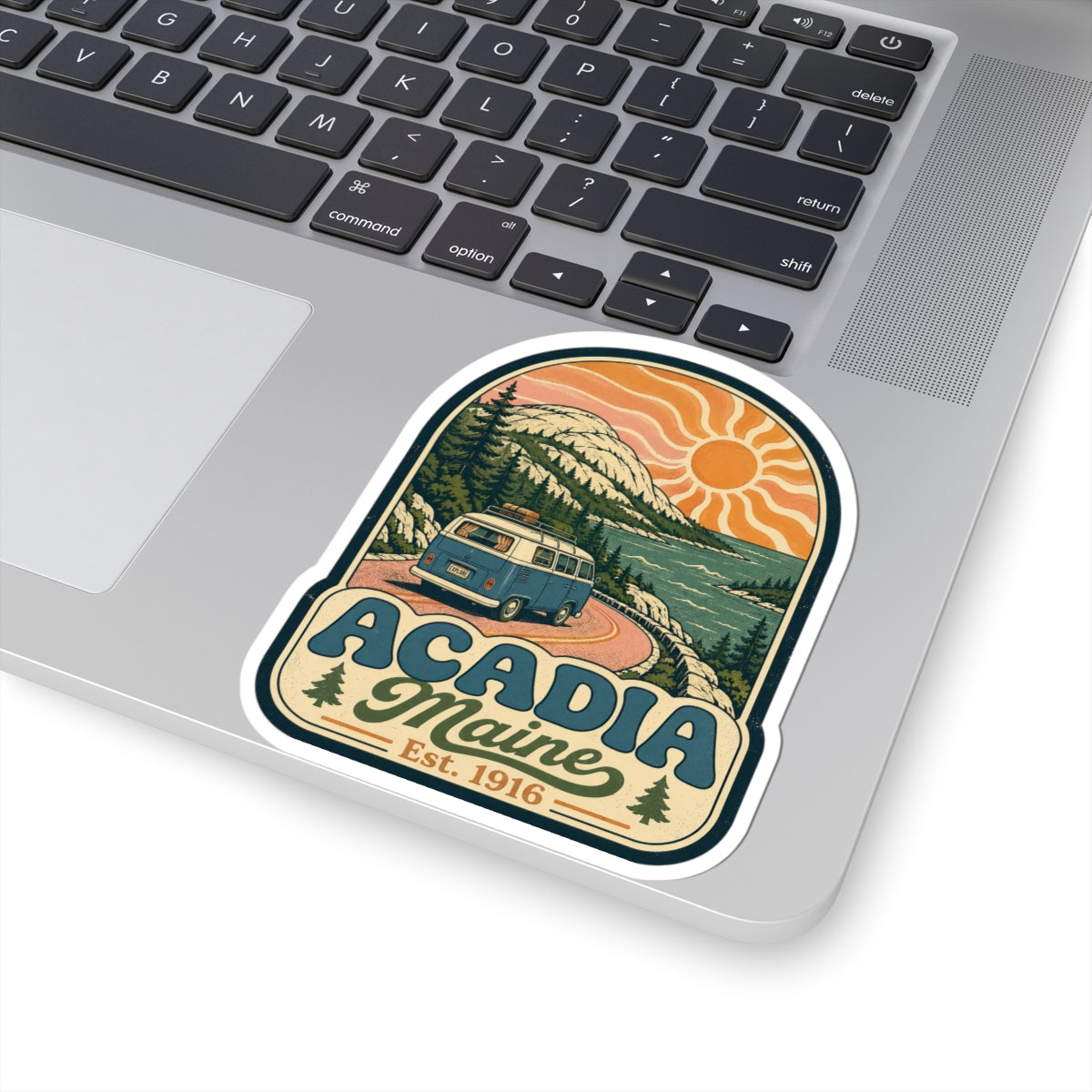 Acadia Maine sticker on laptop lid, vintage camper van with orange sun, Est. 1916
