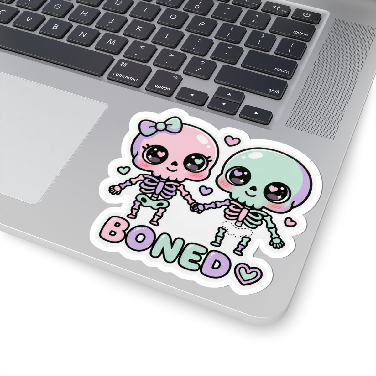 Pastel skull couple sticker with 'BONED' text, bow headband, and heart details