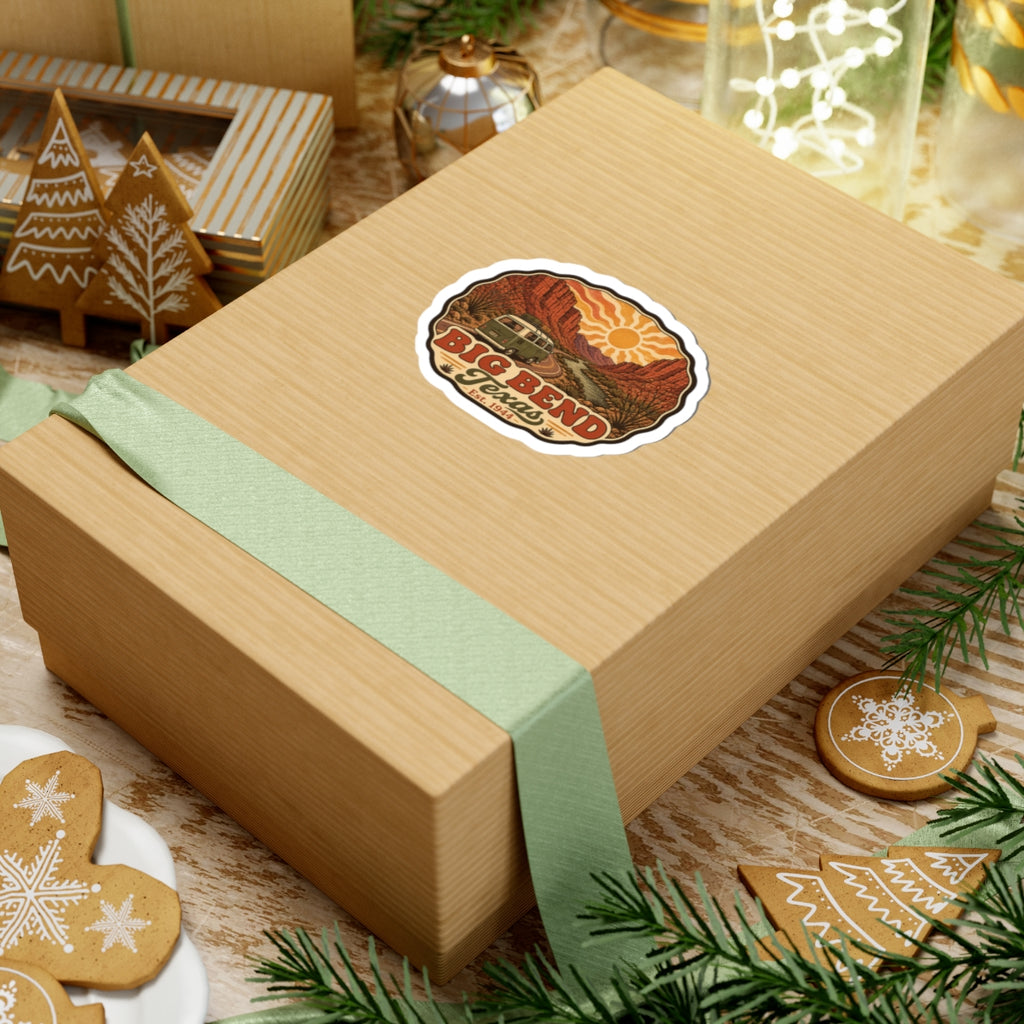 Die-cut road trip sticker on a gift box showing Big Bend Texas desert cliffs and vintage camper
