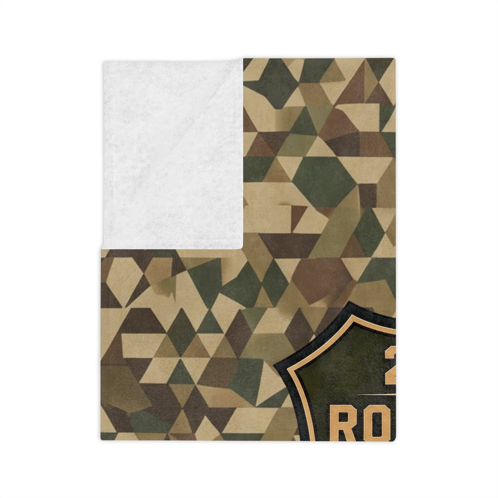 Folded camo microfiber blanket showing geometric pattern and partial embroidered patch