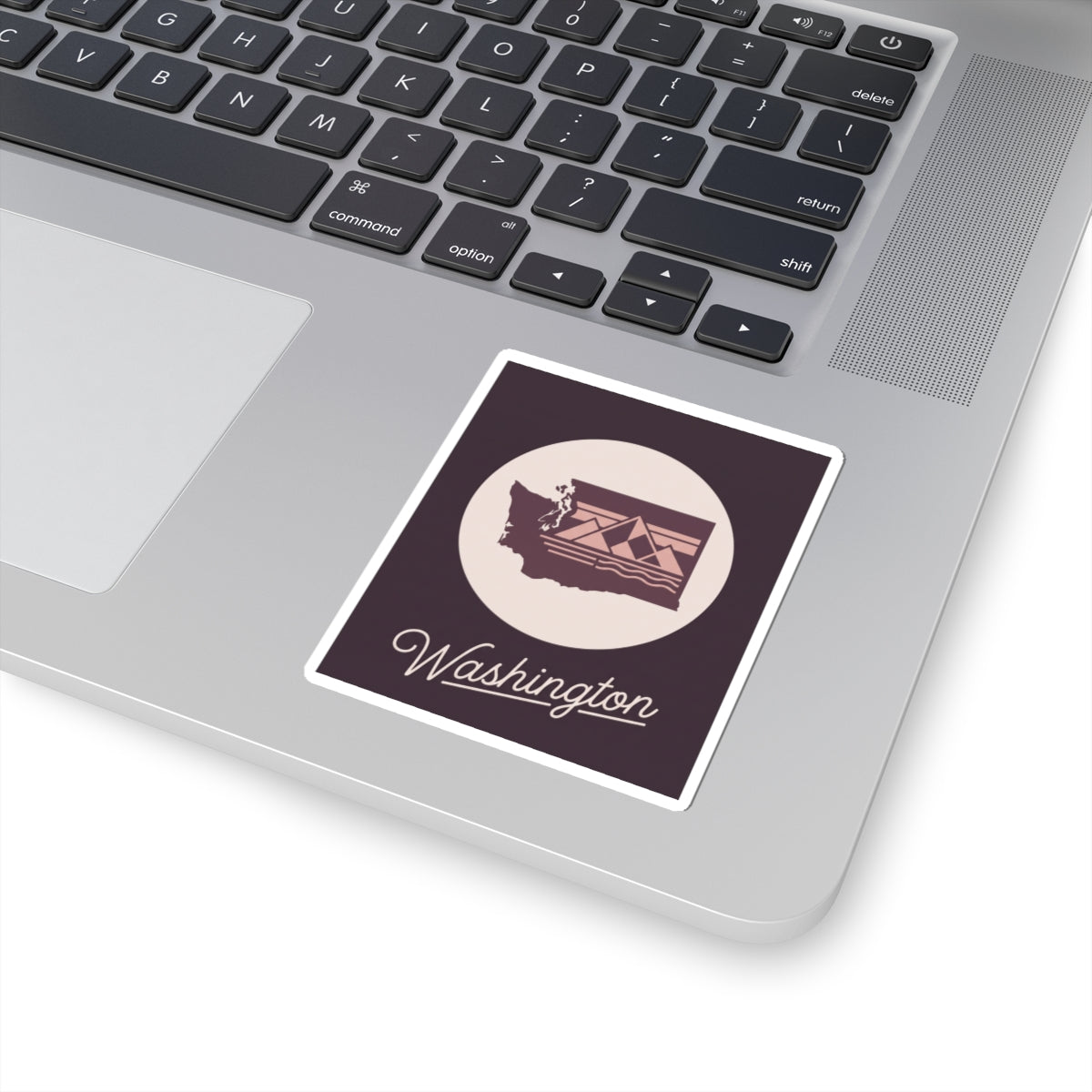 Washington state sticker placed on a laptop keyboard, round emblem with "Washington"