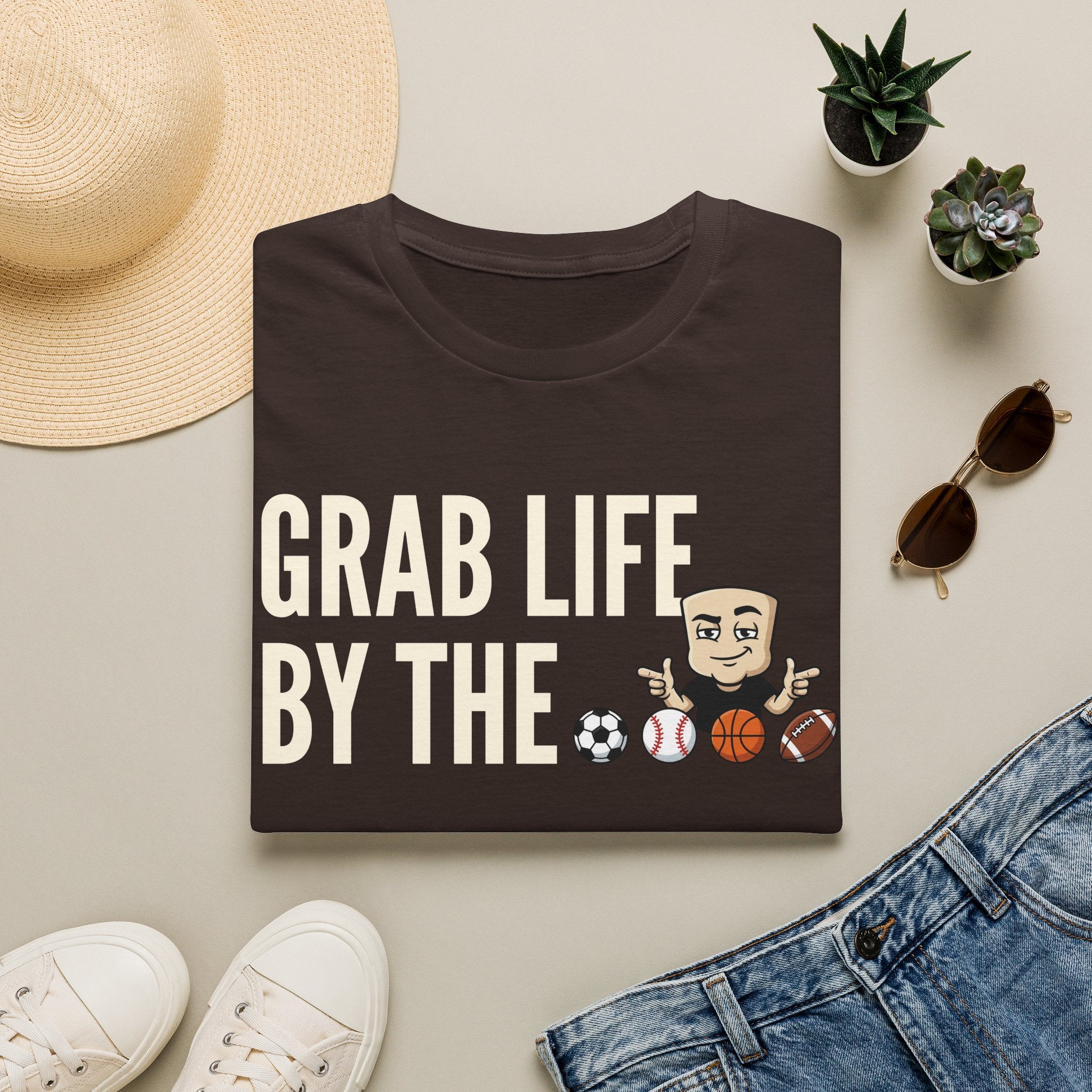 Dark brown T-shirt with “GRAB LIFE BY THE” sports ball graphic and cartoon coach