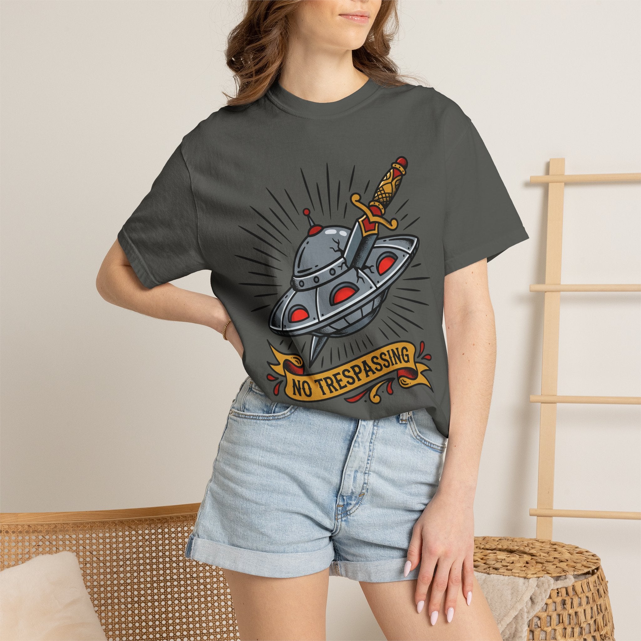 Dark gray T-shirt with cartoon UFO and dagger graphic and “No Trespassing” badge