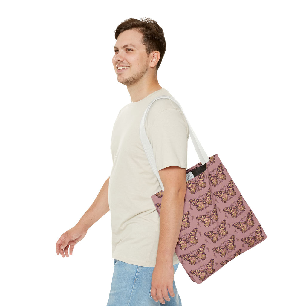 Pink butterfly print tote bag with light handles, carried at the side.