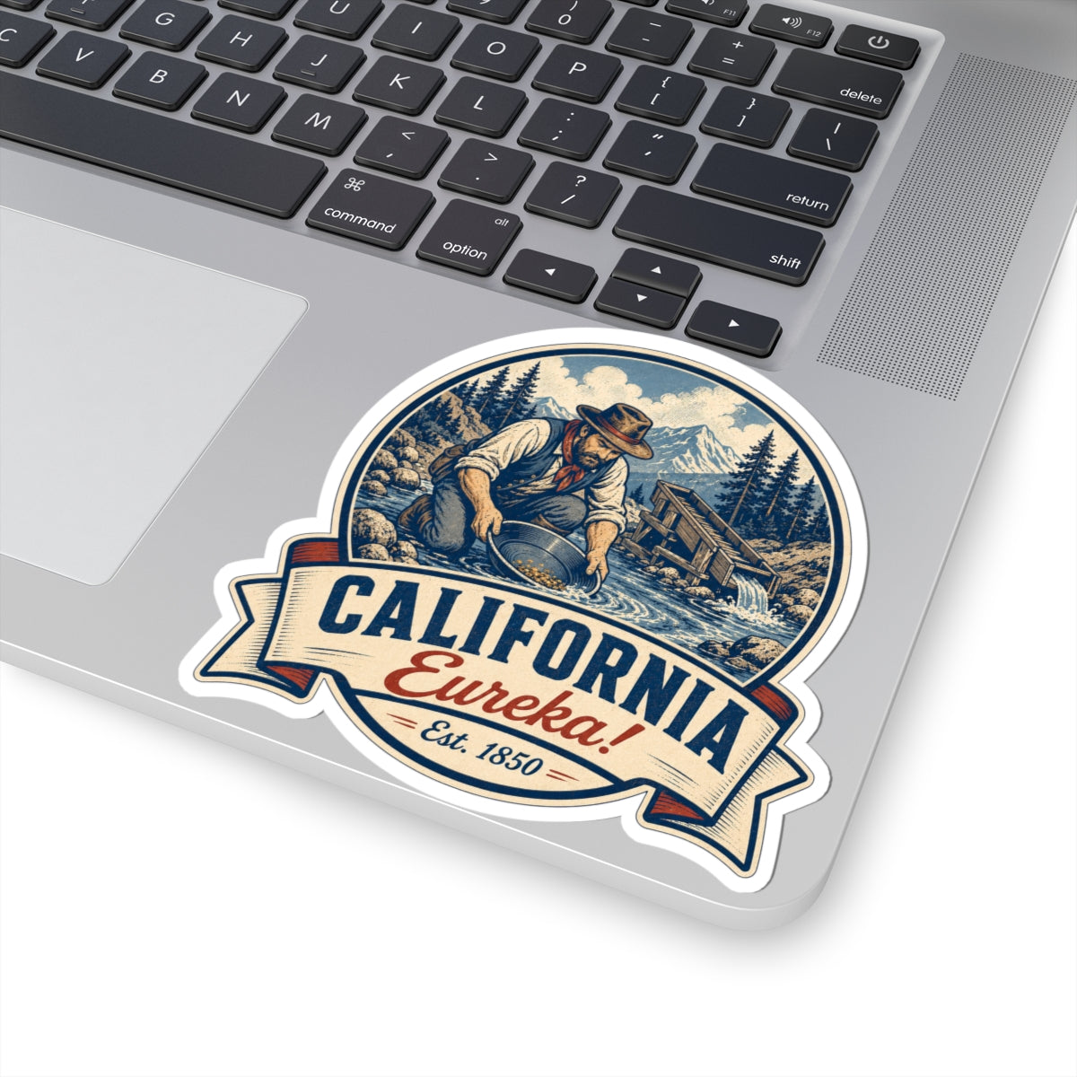 California Eureka! miner badge sticker on laptop trackpad, blue scene and ribbon Est. 1850