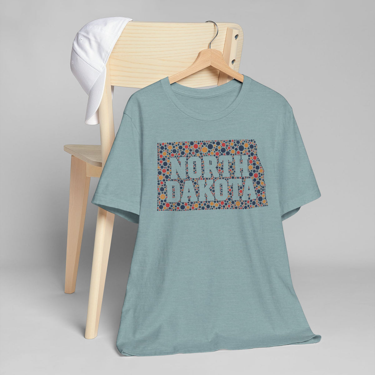 Light teal T-shirt with colorful “NORTH DAKOTA” floral map graphic on front