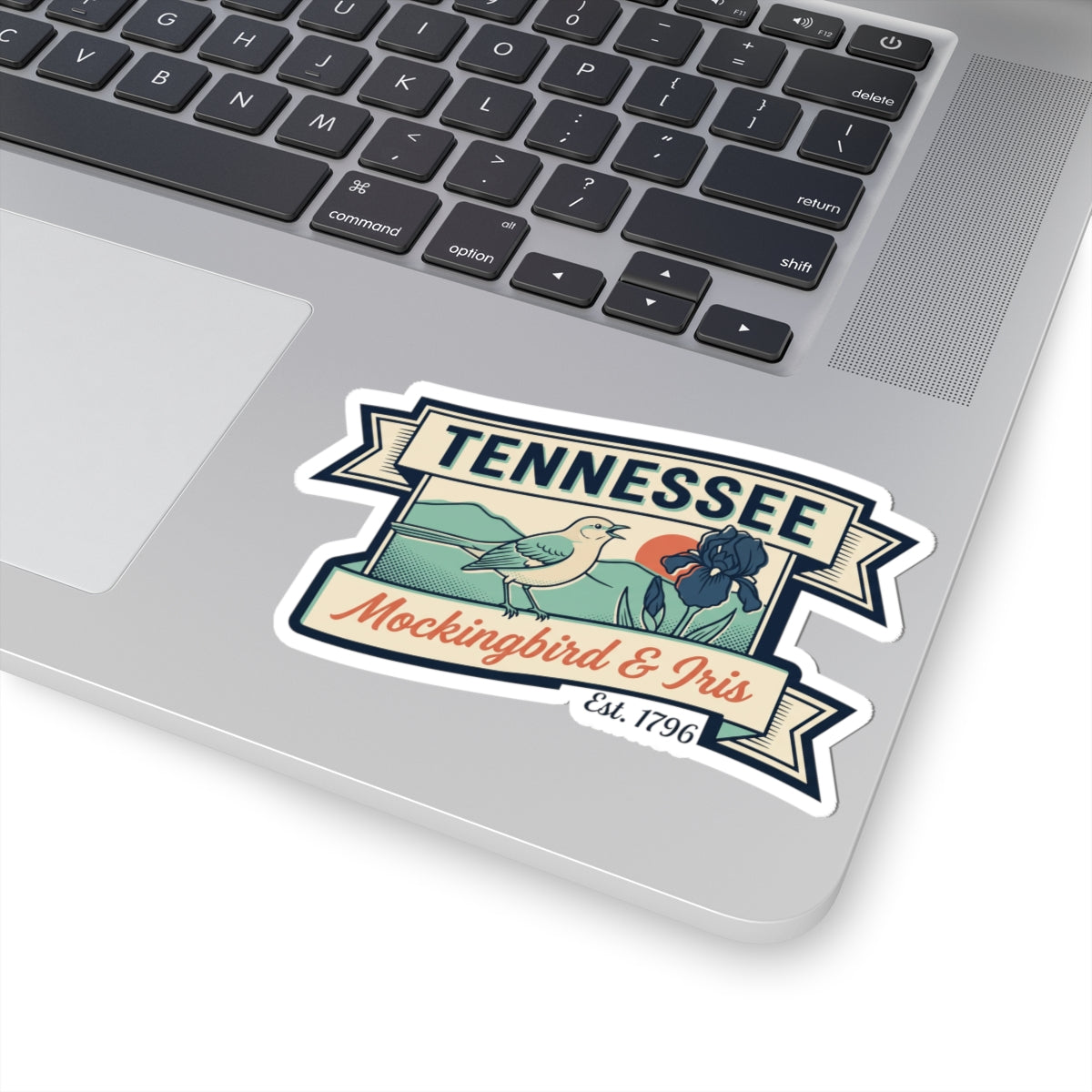 Tennessee decal sticker on a laptop trackpad area, showing mockingbird and iris