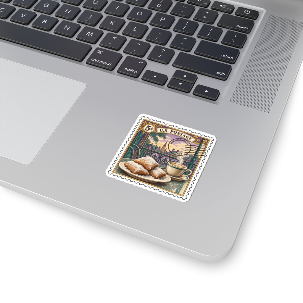 Kiss-cut vinyl sticker on laptop, small vintage postage stamp art with beignets and coffee