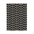 Velveteen plush blanket square view with winged skull repeat pattern in gold on dark