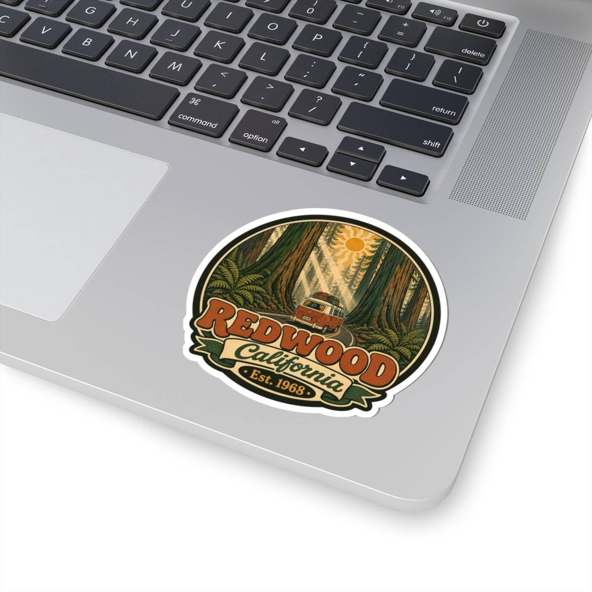 Round sticker with redwood forest graphic, camper van, “Redwood California” and “Est. 1968.”