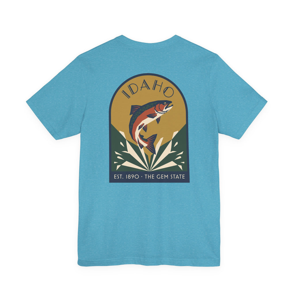 Aqua blue crewneck t-shirt with circular Idaho trout badge graphic and "EST. 1890 • THE GEM STATE" text.