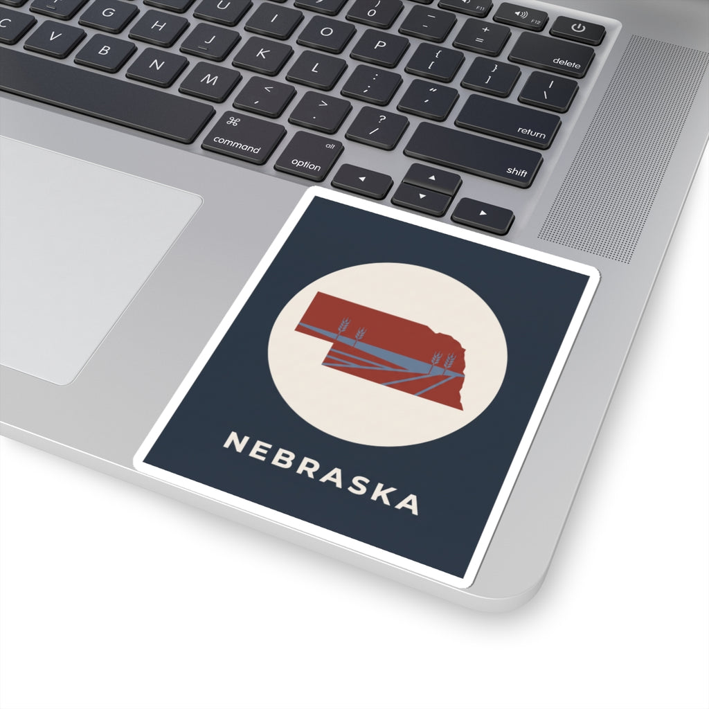 Nebraska sticker with navy background, white circle, red state map, and “NEBRASKA”