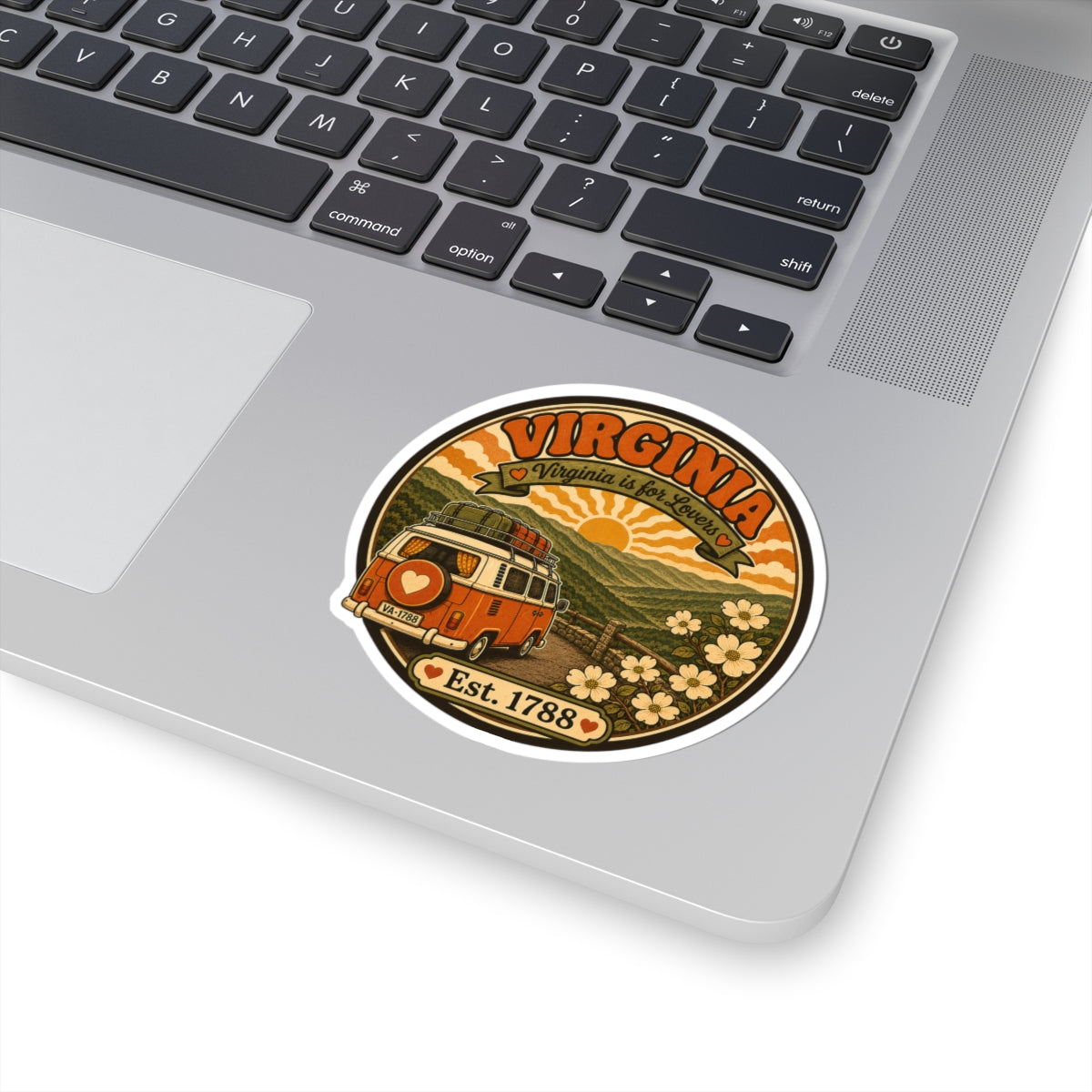 Circular orange and brown van sticker placed on a laptop surface