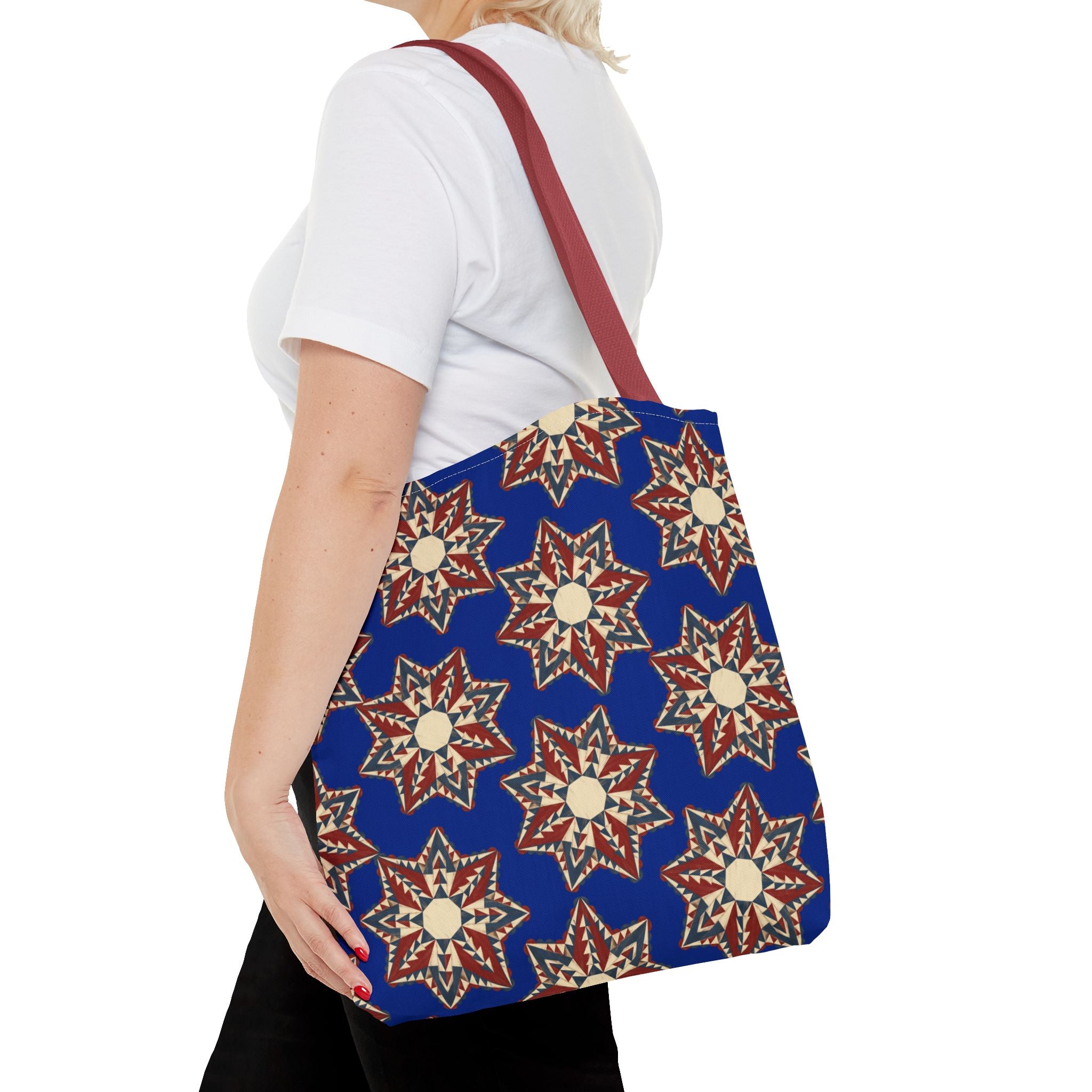 Blue tote bag with red and cream starburst floral pattern, red shoulder straps