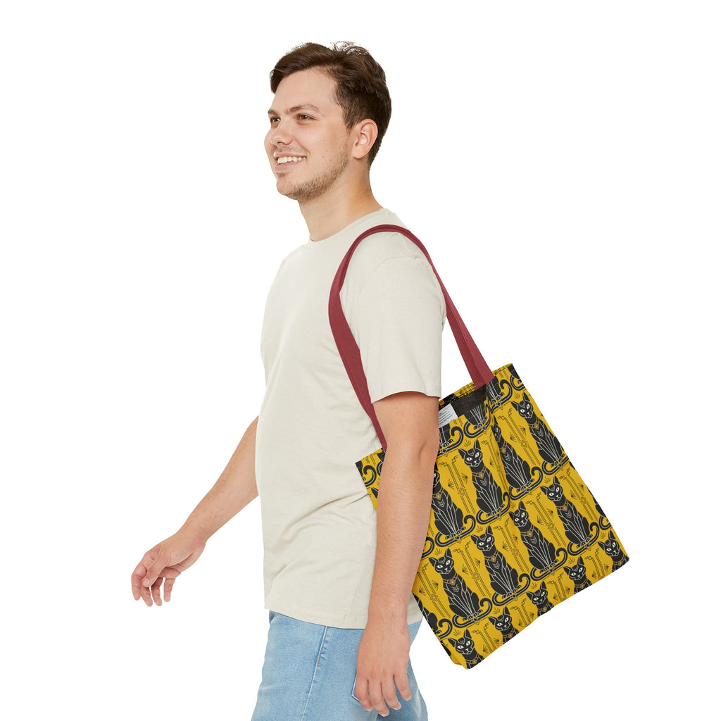 Yellow tote bag with black Art Nouveau cat pattern worn with red shoulder straps