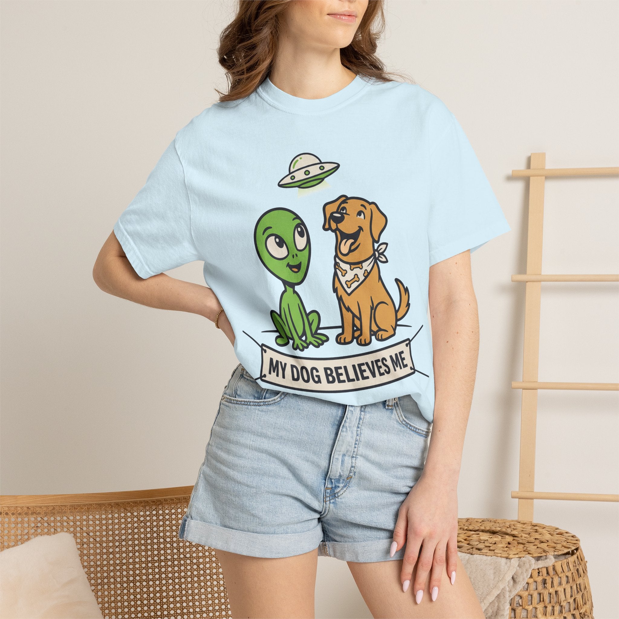 Light blue T-shirt on model with alien and dog graphic and slogan