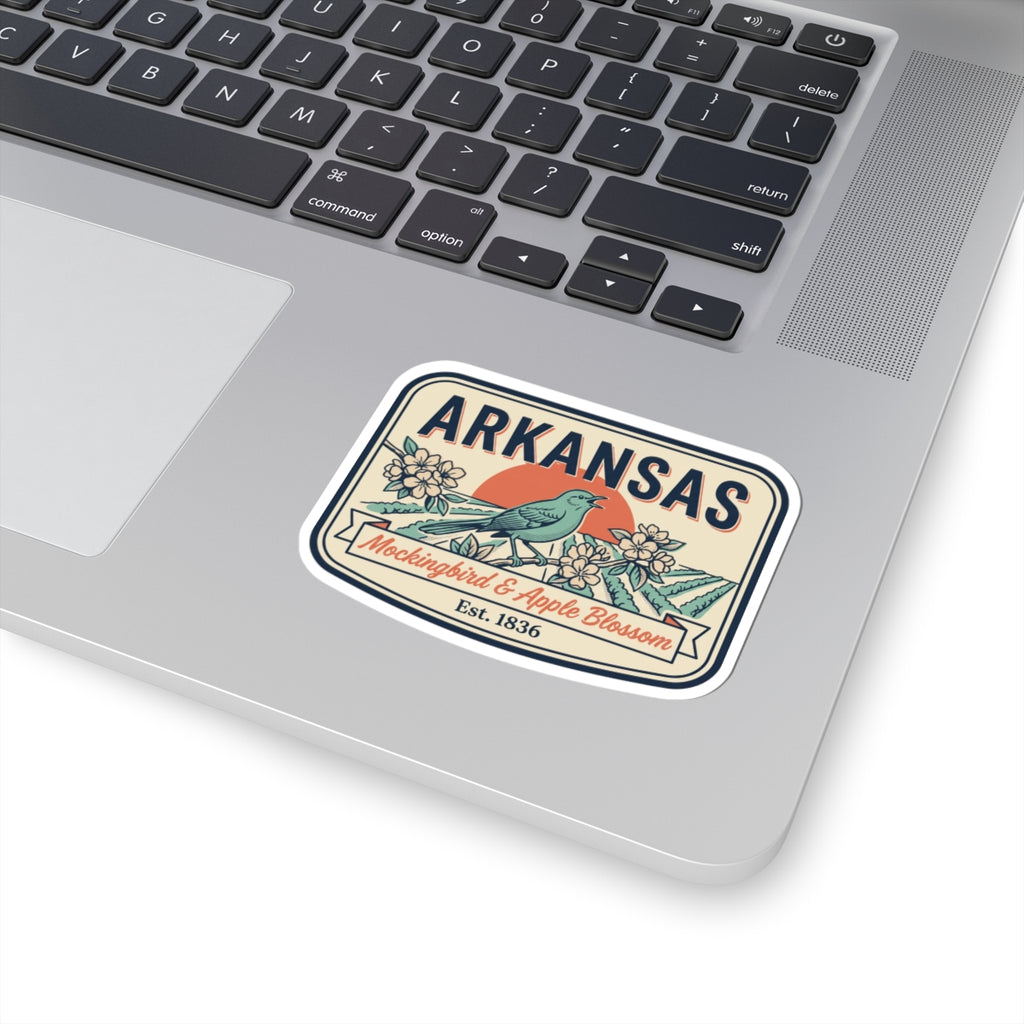 Arkansas vintage badge sticker on a laptop lid, with blue bird, flowers, and “Est. 1836”