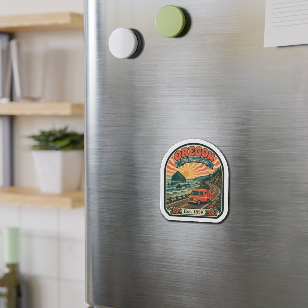 Oregon die-cut travel magnet on brushed-metal fridge door with orange van and “Est. 1859”