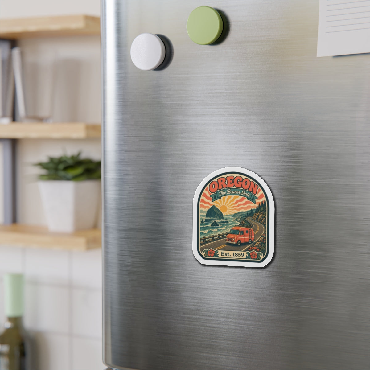 Oregon die-cut travel magnet on brushed-metal fridge door with orange van and “Est. 1859”