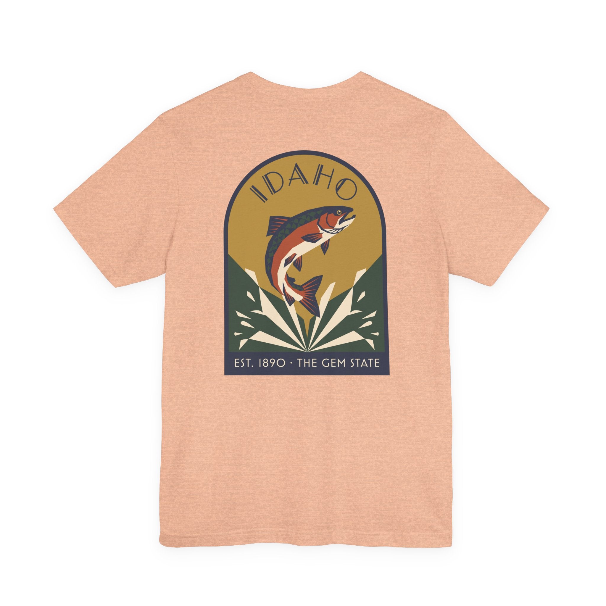 Light peach crewneck t-shirt with circular Idaho trout badge graphic and "EST. 1890 • THE GEM STATE" text.