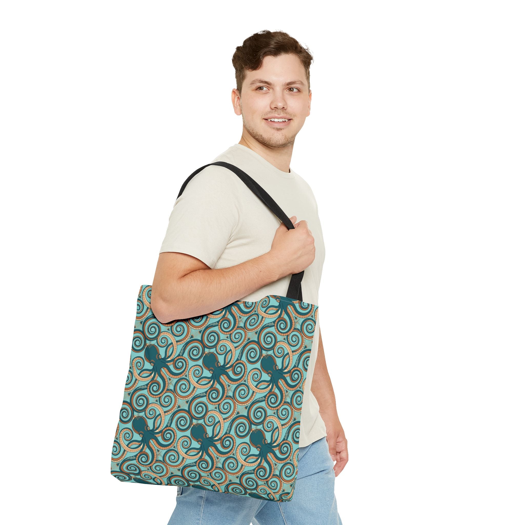 Teal octopus swirl tote bag with black strap, carried