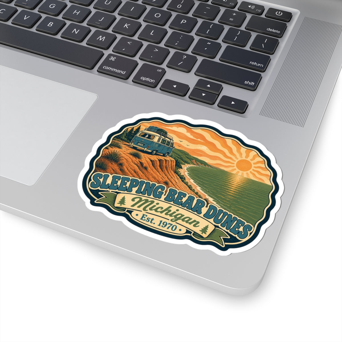 Die-cut sticker featuring camper van, rolling dunes, water with shoreline, and “Sleeping Bear Dunes” text