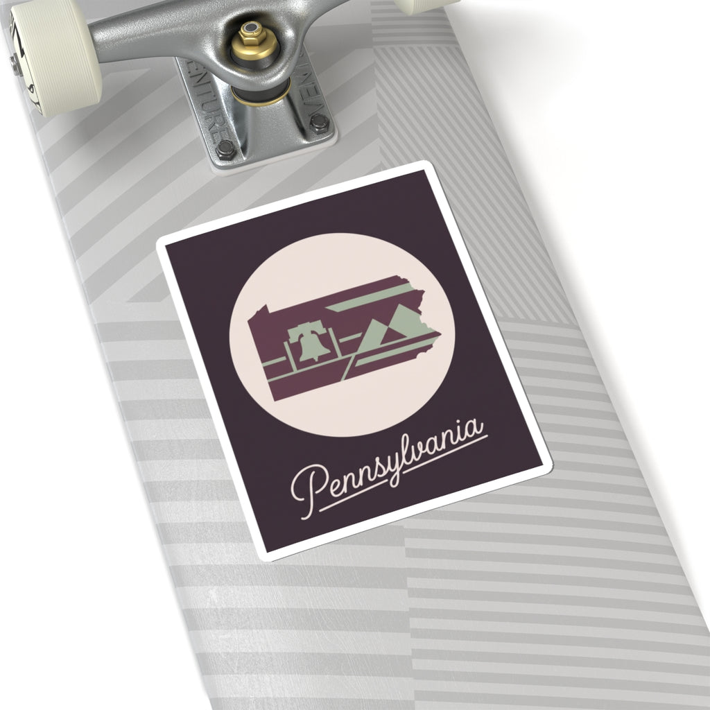 Pennsylvania state silhouette kiss-cut decal on skateboard deck, purple and green with “Pennsylvania”