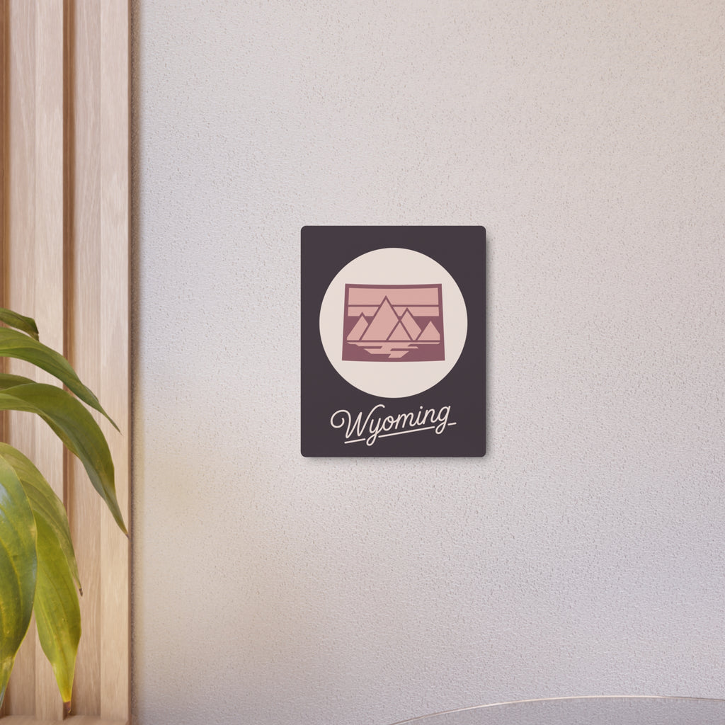 Square mauve metal wall art with oval landscape emblem and “Wyoming” cursive text