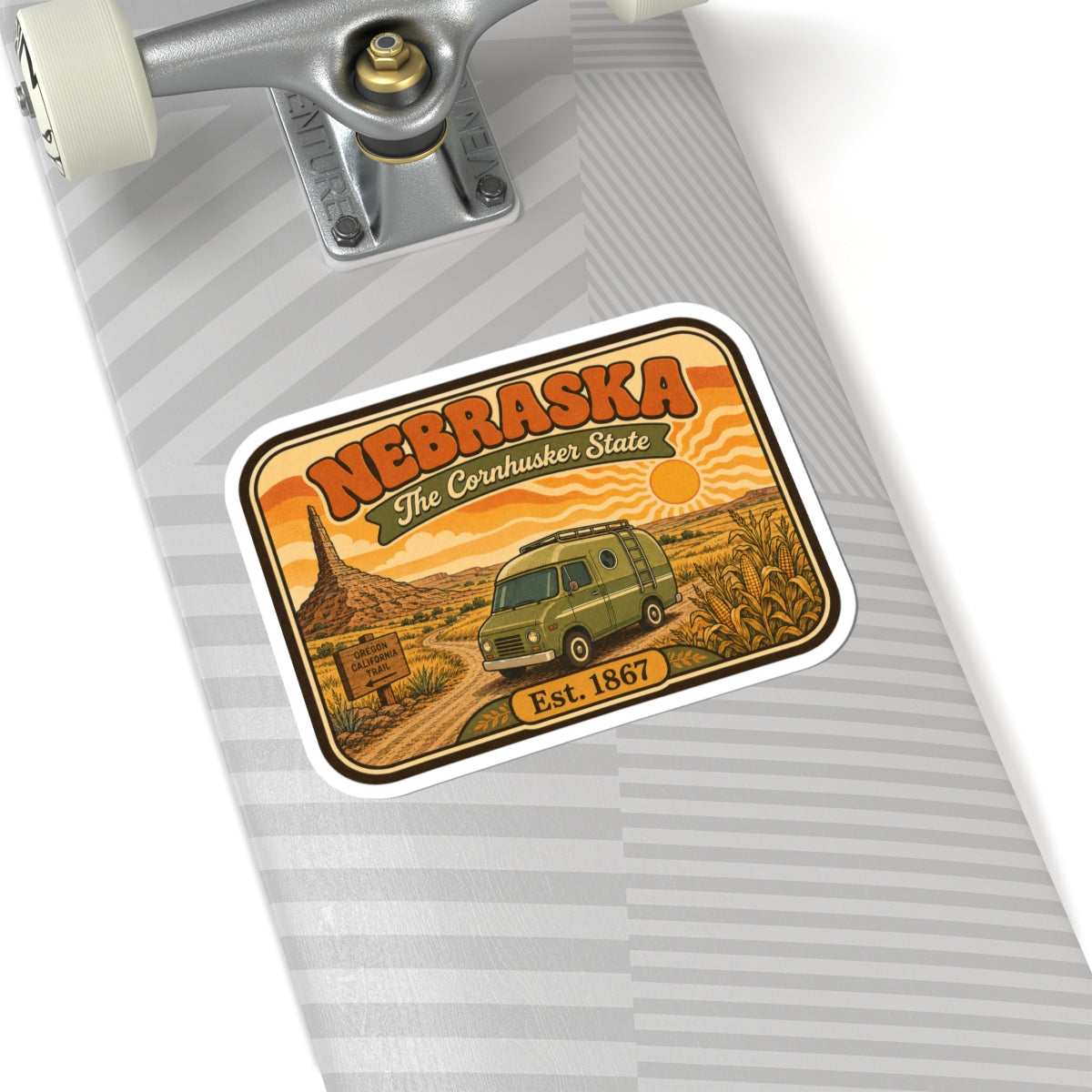 Nebraska travel sticker on a grey striped surface, green van and “Est. 1867” text.