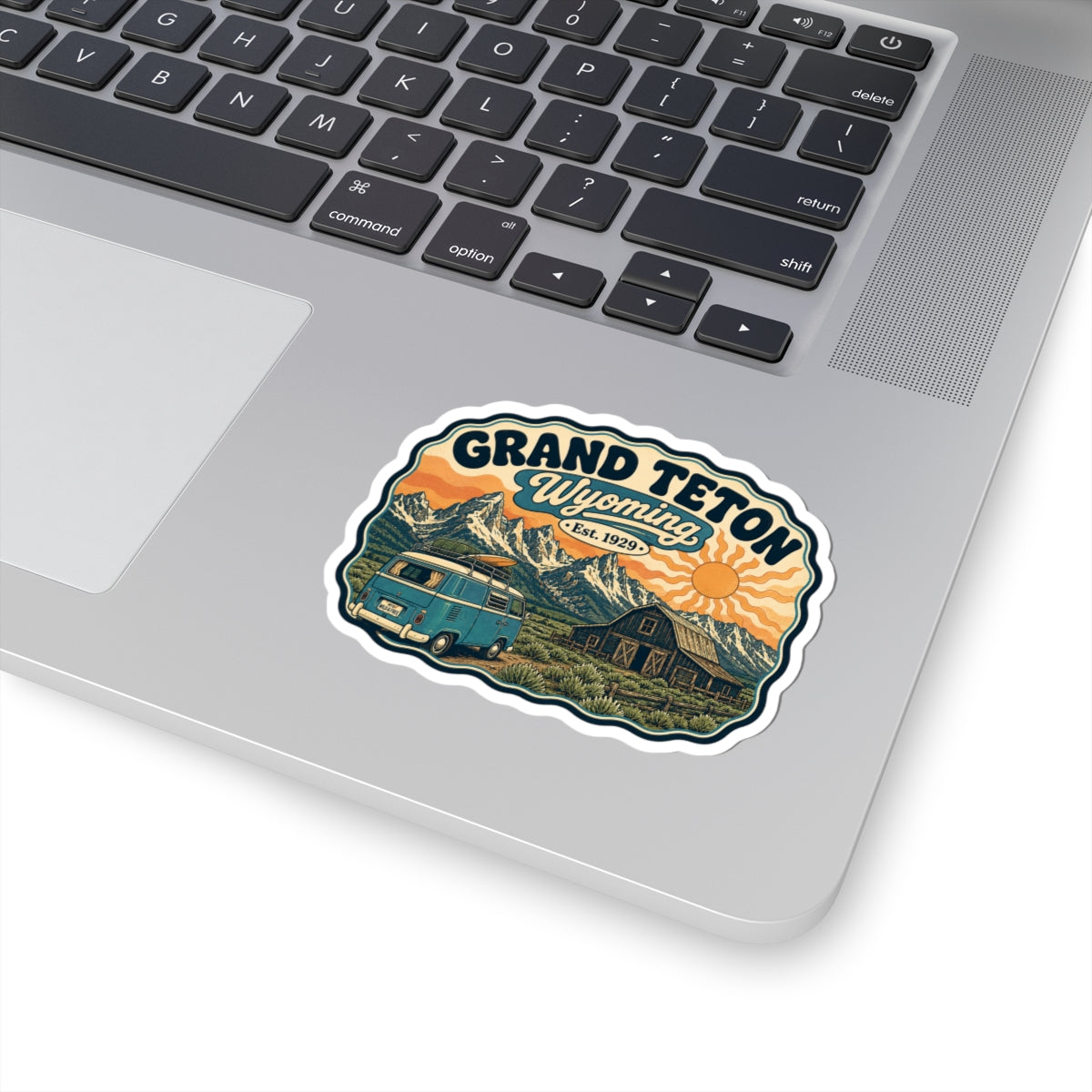 Grand Teton Wyoming sticker design: teal camper van, barn, mountain range, and orange sun