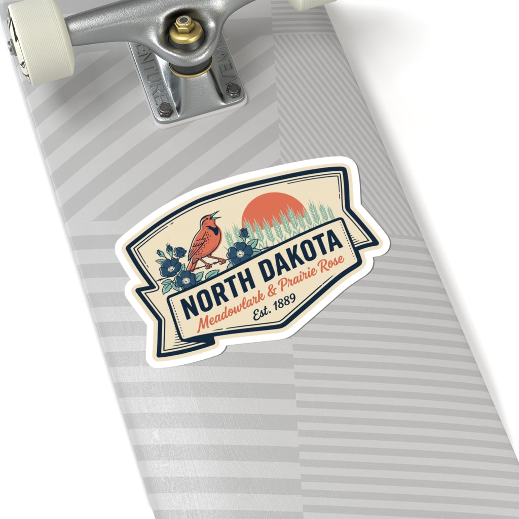 North Dakota kiss-cut vinyl sticker with bird scene, prairie grass, and “Est. 1889”