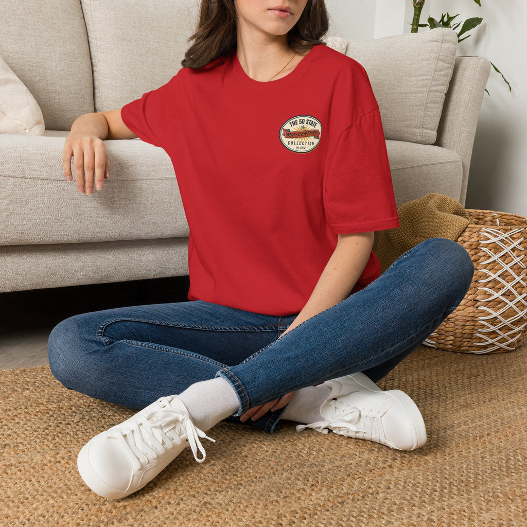 Red crewneck T-shirt with small circular chest logo graphic, worn with jeans.