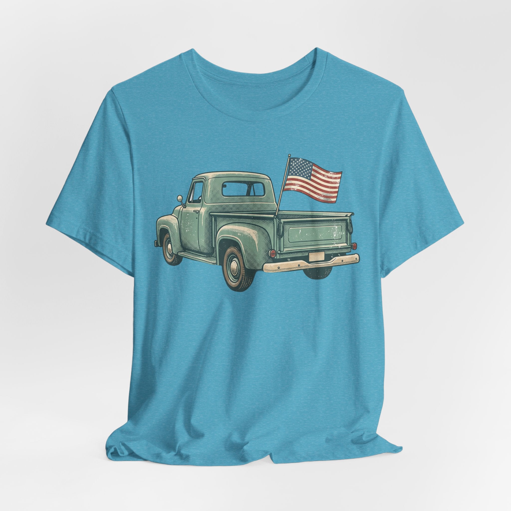 Light blue crewneck T-shirt featuring a vintage green pickup truck with an American flag.