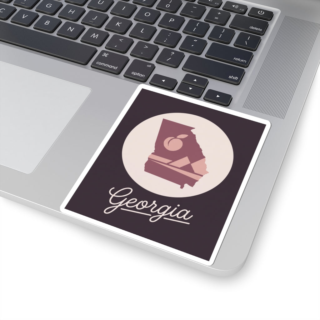 Mauve Georgia state silhouette vinyl decal on laptop with circular emblem and Georgia script