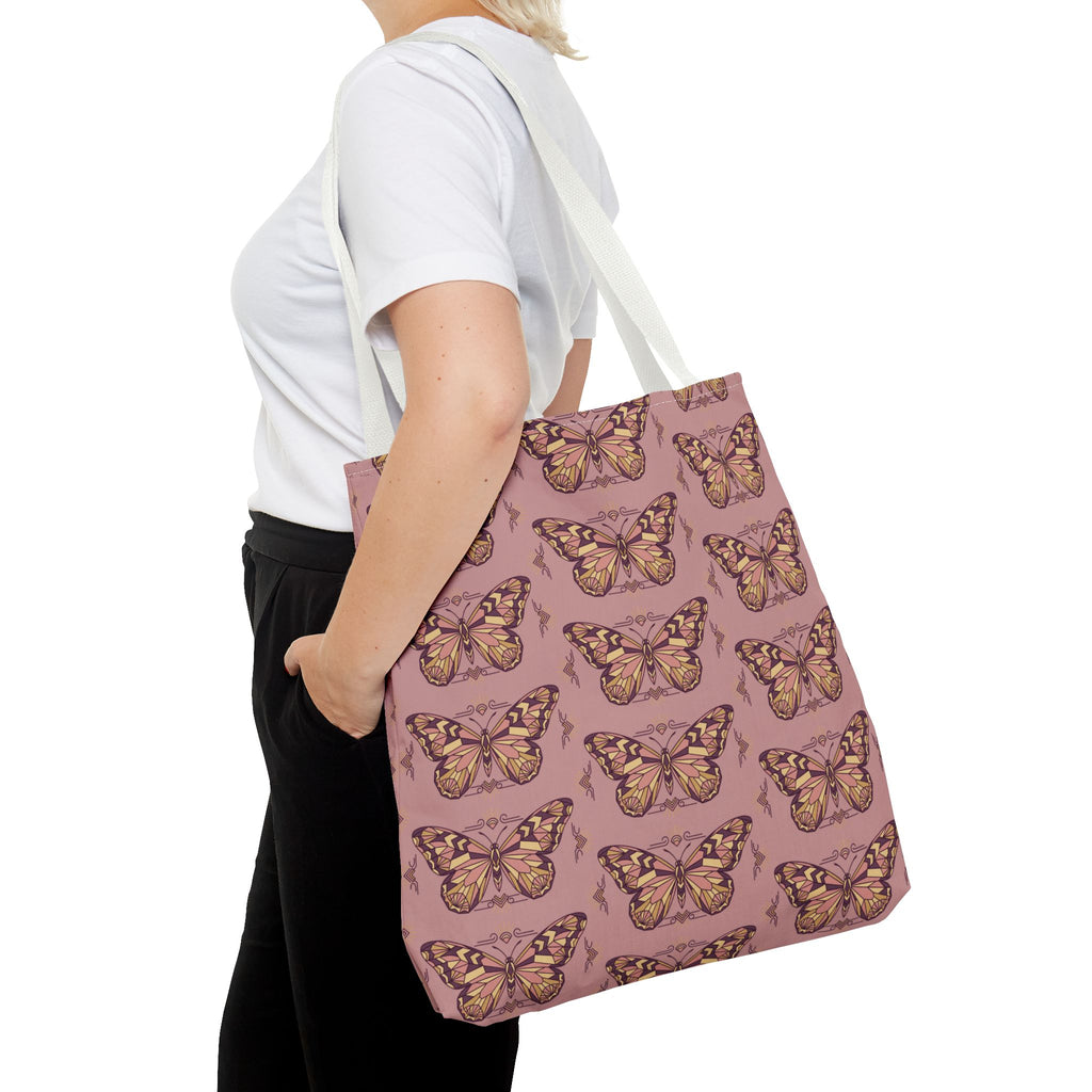 Pink butterfly print tote bag with light handles, side view on shoulder.
