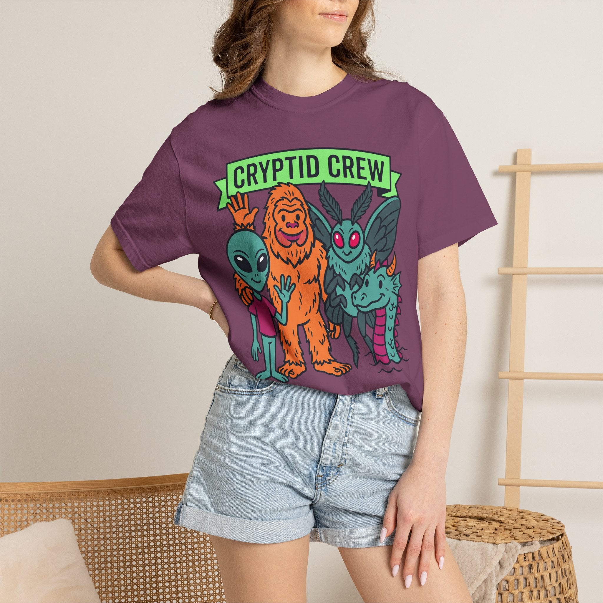 Plum crew neck t-shirt with multicolor cryptid graphic and green 'CRYPTID CREW' text