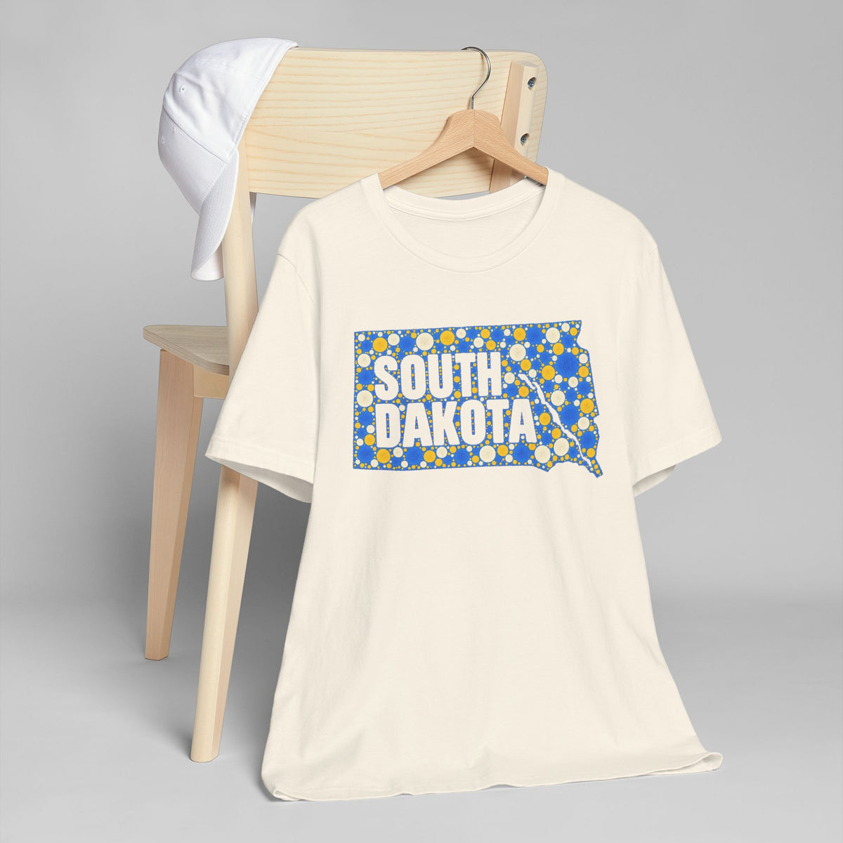 Cream crew-neck t-shirt with blue and yellow South Dakota map graphic on front.