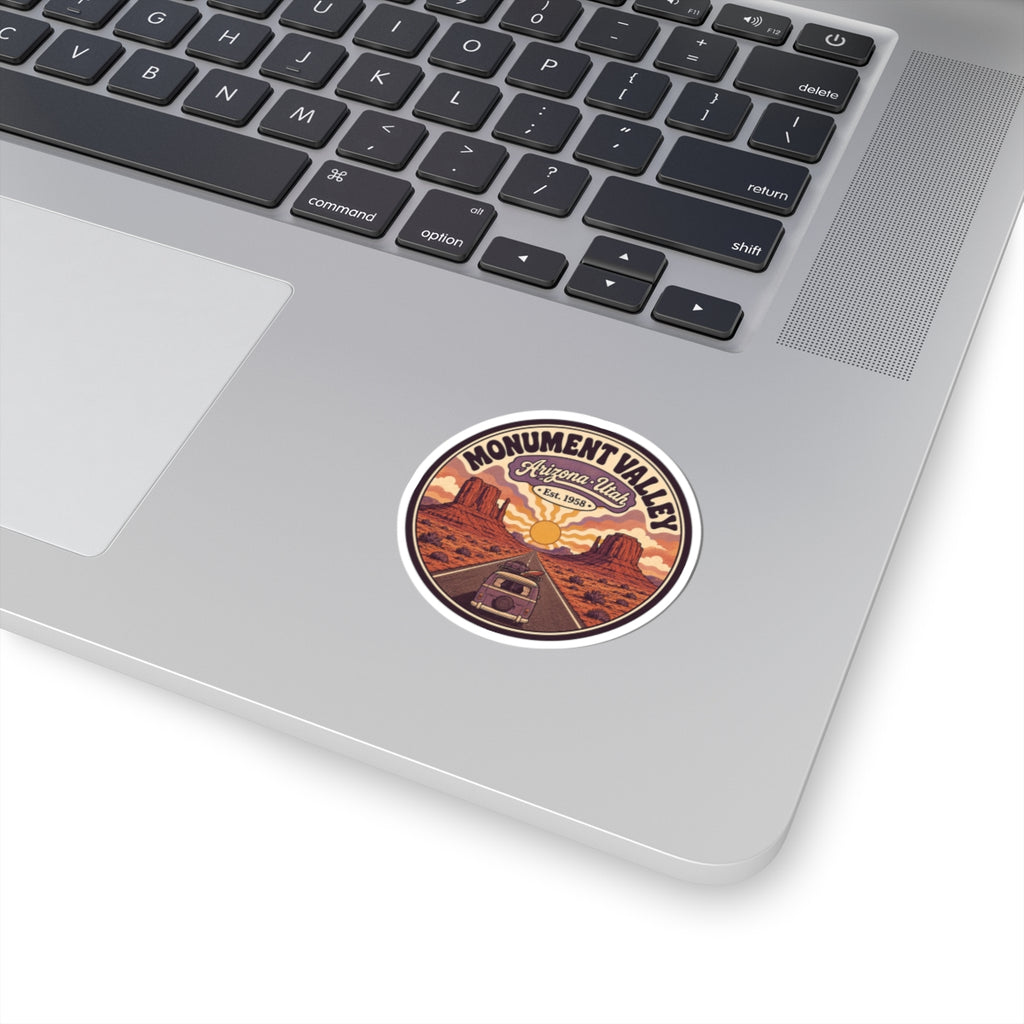 Round kiss-cut sticker with desert road, sunset sky, and Monument Valley text