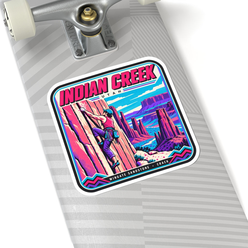 Square “INDIAN CREEK” sticker on a gray striped board with climber and rock canyon image