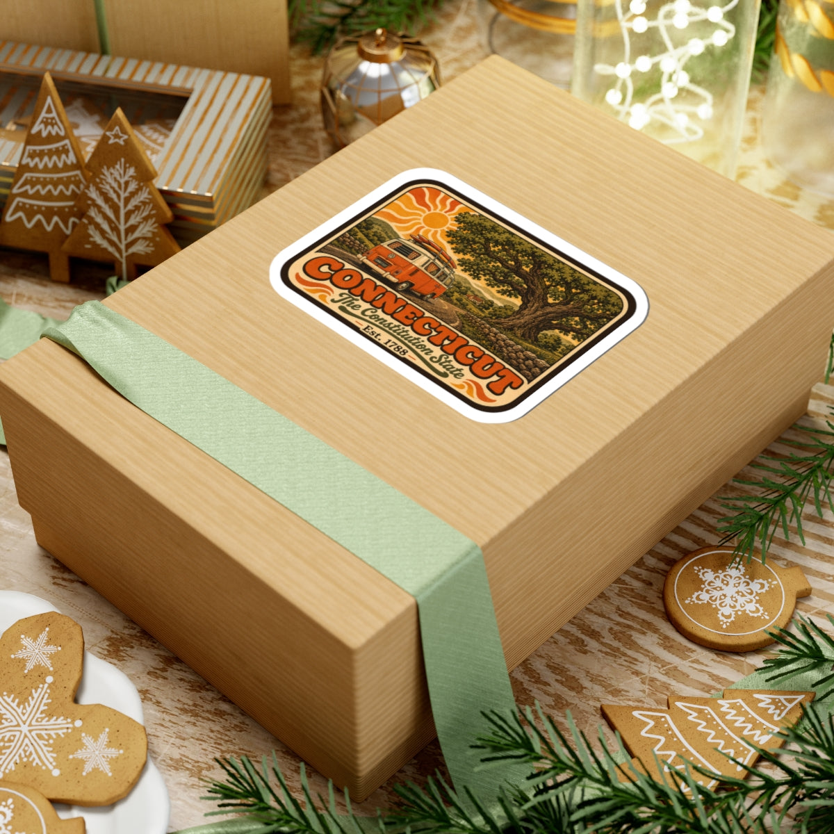 Connecticut camper van sticker on a gift box near greenery and holiday cookies.