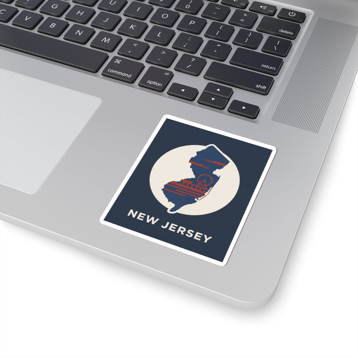 NJ map kiss-cut sticker, angled view: navy badge with white circle and red-blue striped state