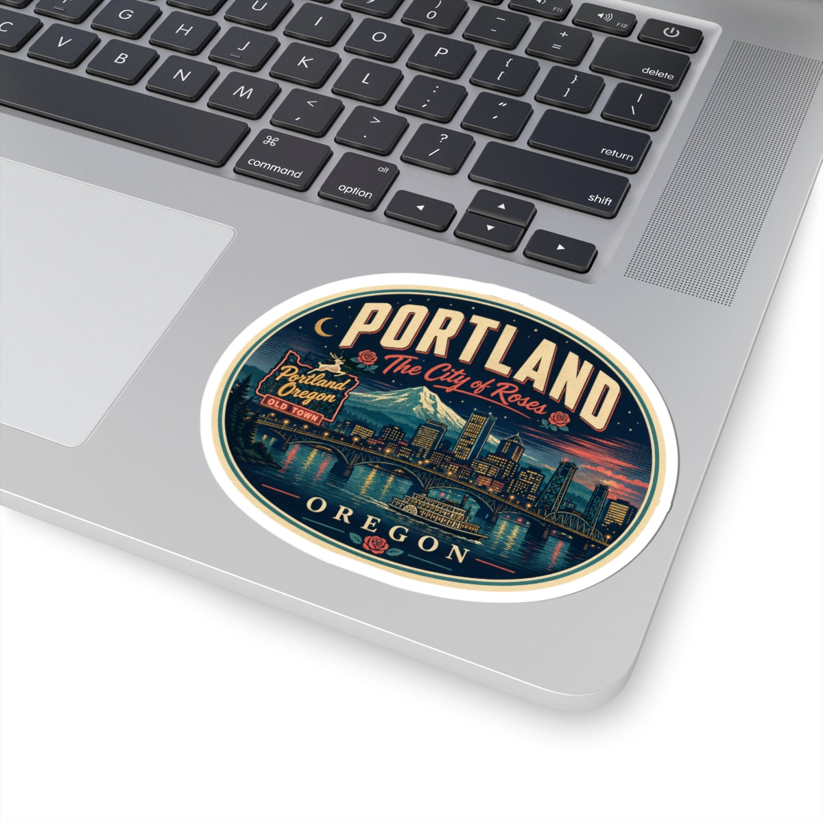 Round Portland Oregon luggage tag sticker on laptop keyboard, “OREGON” text at bottom