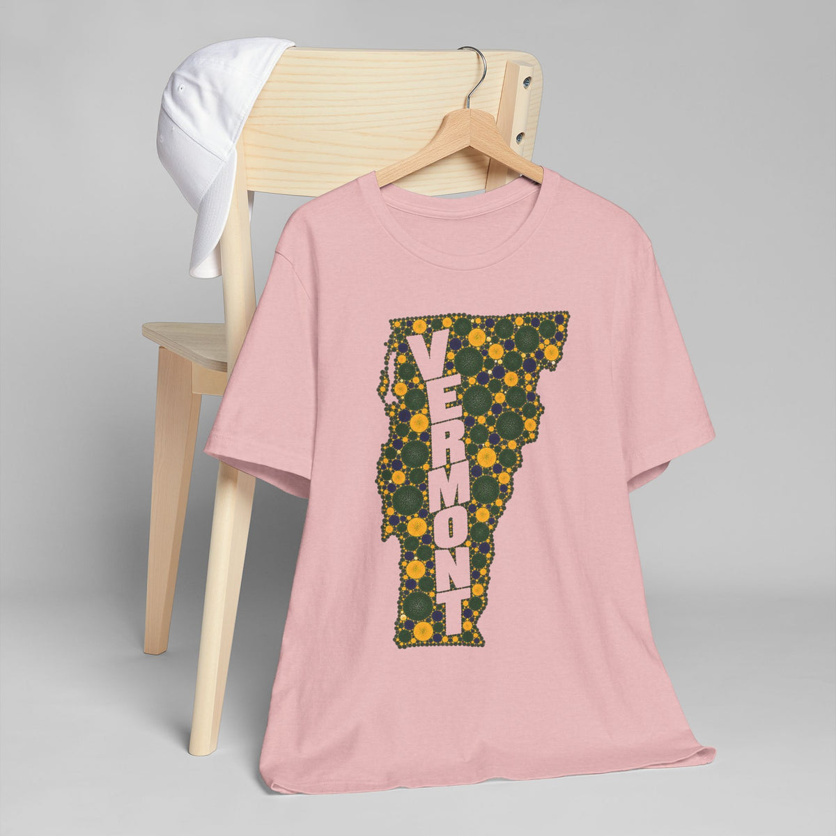 Light pink crew-neck T-shirt with floral Vermont map outline graphic in green and gold
